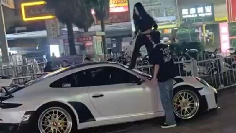 一名女子站在一輛跑車上，情緒激動地狂踹前擋風玻璃。（圖／翻攝自微博）