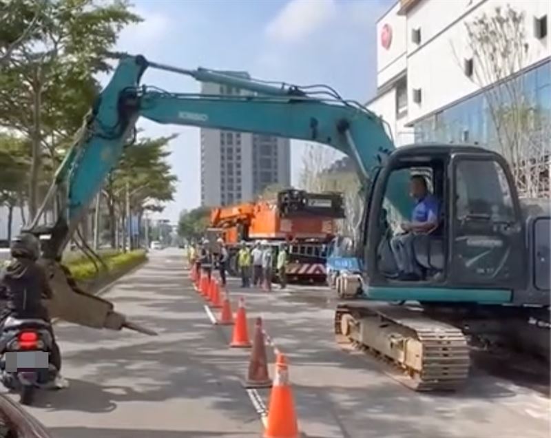怪手將鏟斗延伸至道路上，阻擋騎士及後方車輛通行。（圖／翻攝畫面）