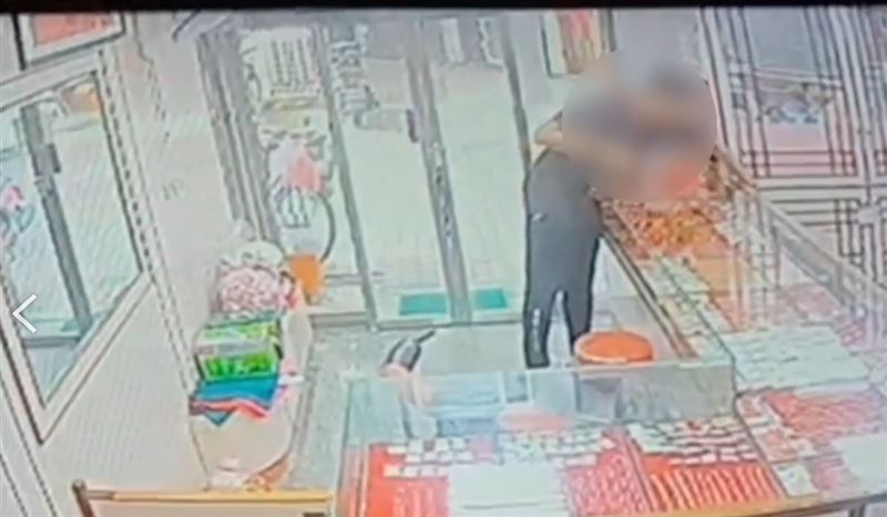 王男趁老闆不注意搶走金飾。（圖／翻攝畫面）