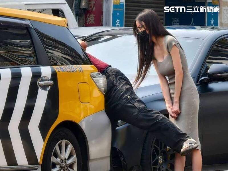 正妹不斷的向計程車司機致歉，並彎身查看車輛受損狀況。她態度誠懇，積極關心事故細節，一度要爆器的司機立刻氣消。（圖／民眾提供）