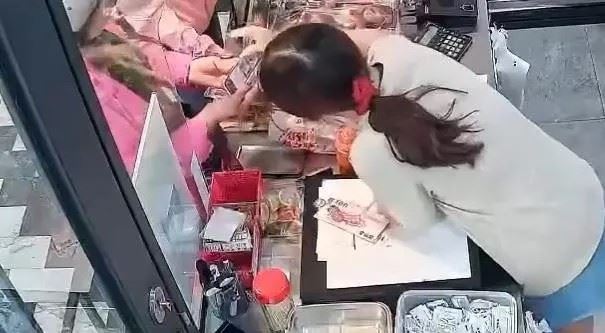 女店員用手機播放監視器畫面，跟婦人確認她剛剛是用500元鈔票付款。（圖／翻攝Threads＠chiming697）