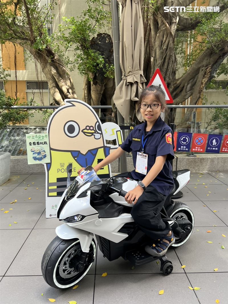 「小小警察」在飯店2樓咖啡廳露臺旁的百年榕樹下，騎乘警用機車，學習交通觀念。（圖／記者林昱孜攝影）