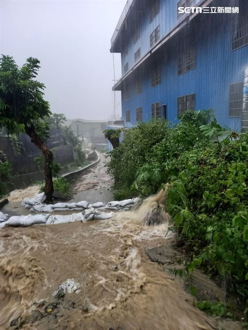 山坡地瞬間湧出大量夾帶土石的黃泥水，猶如「土石流瀑布」般傾瀉而下，瞬間覆蓋整條道路。(圖/民眾提供)