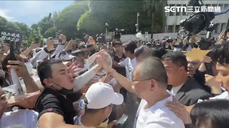 民眾黨前主席柯文哲與小草握手，吃屎哥突然亂入撒冥紙。（圖／記者楊忠翰攝影）