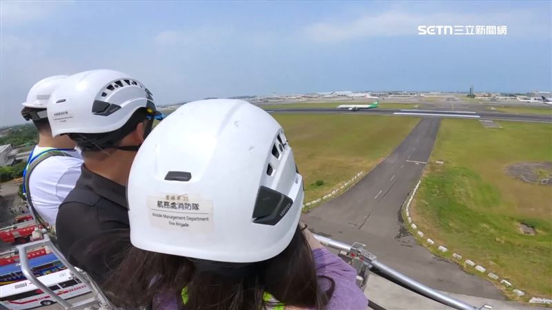 學員坐上五六層樓高的雲梯車，近距離看飛機在跑道上滑行