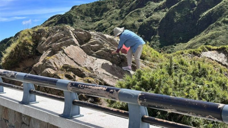 藍衣大媽上合歡山武嶺亭，涉險拍美照。（圖／翻攝自爆料公社）