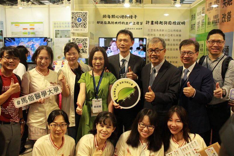 大合照中間持手拿板者為馬偕醫大校長葉宏一，後排右一為教育部高教司廖高賢司長、右二為教育部USR計畫總主持人台北醫學大學林建煌講座教授、右三為教育部鄭英耀部長。（圖／馬偕醫大提供）