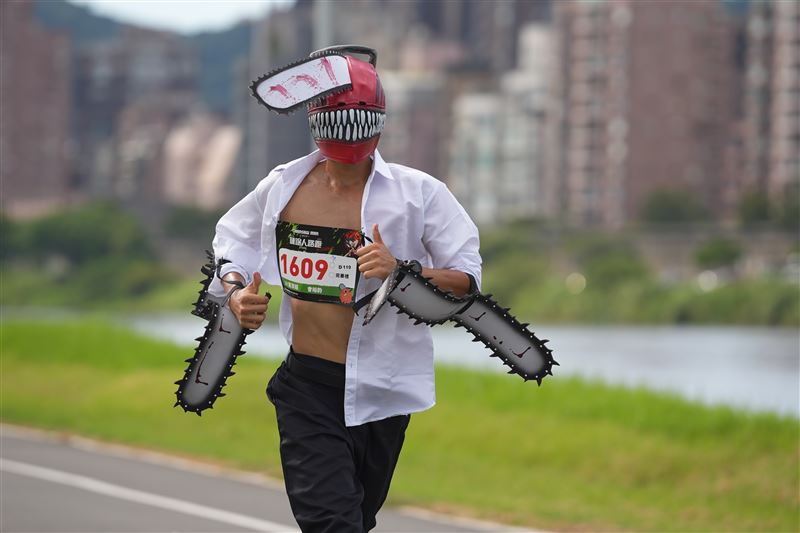 熱情粉絲戴著鏈鋸頭套跑步。（圖／索尼影業提供）