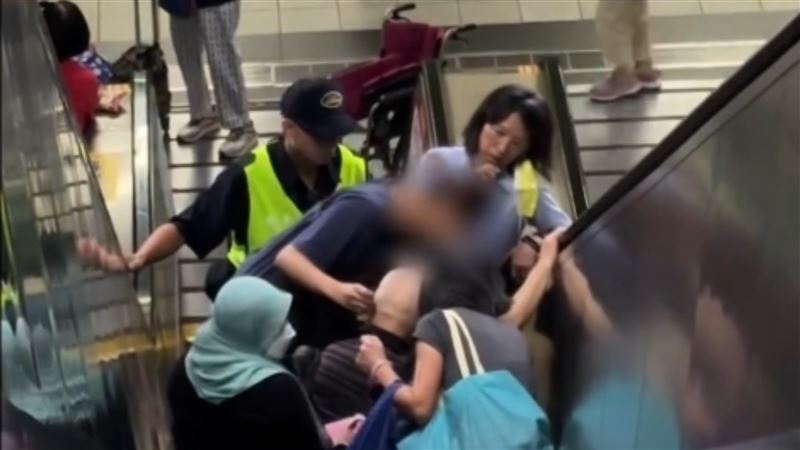 台北捷運永春站昨(13)日下午4點傳出事故,一名外籍看護推著坐輪椅的長者誤上電扶梯,行至半途時因重心不穩,輪椅整台翻倒,導致長者與看護雙雙受傷,後方一名女乘客也被波及。(圖/網友bebetty1210授權提供,未經同意請勿轉載)