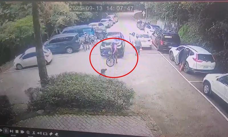 單車騎士發現休旅車靠近趕緊移車，卻來不及閃避，被撞進樹叢，路人嚇得趕緊跳開險遭波及。(圖／翻攝畫面)