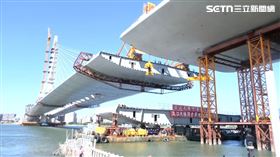 淡江大橋進行合龍前的起吊測試畫面首度曝光。工程團隊透過精密測試，確認吊裝端口的高程與寬度均符合標準，為明（16）日安裝最後一塊「閉合節塊」，並舉行合龍祈福儀式做好準備。(圖／三立新聞)