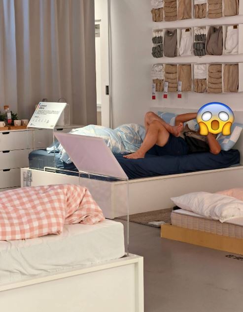 內湖IKEA驚見男子「赤腳躺床」,鞋子和襪子都脫了,翹著腳滑手機畫面,彷彿在自己家。(圖/翻攝自爆料公社)