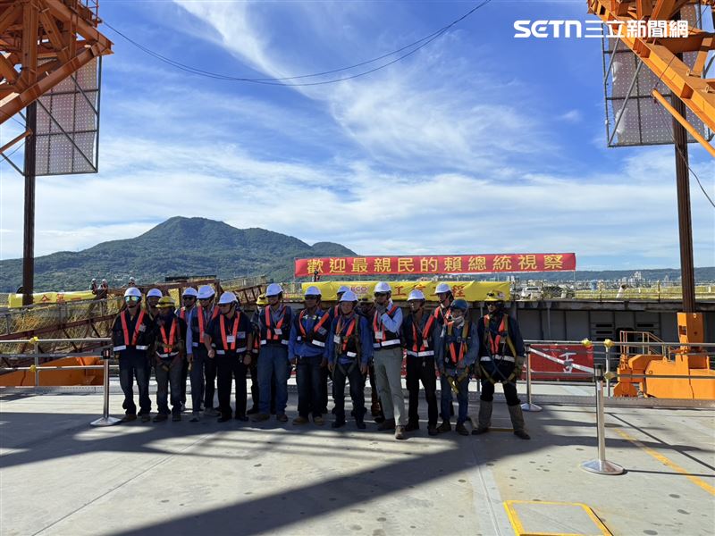 記者上午8點40分左右拍攝淡江大橋工作團隊在合影，拍下此畫面時，紅布條還在。（圖／記者李育道攝影）