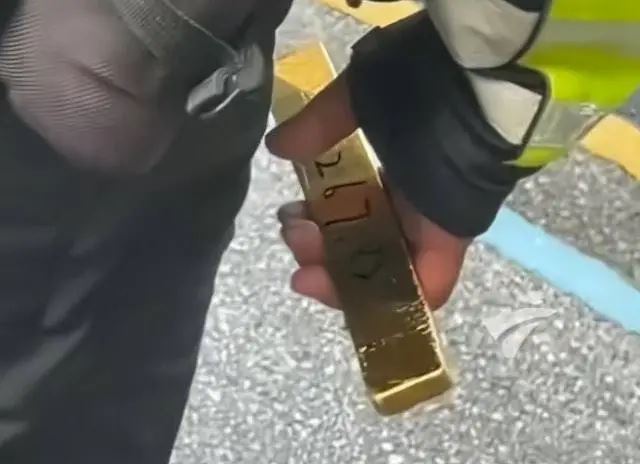 大陸一名交警手中竟然拿著沉甸甸的「金條」指揮交通，畫面曝光後迅速引發輿論熱議。(圖/微博)
