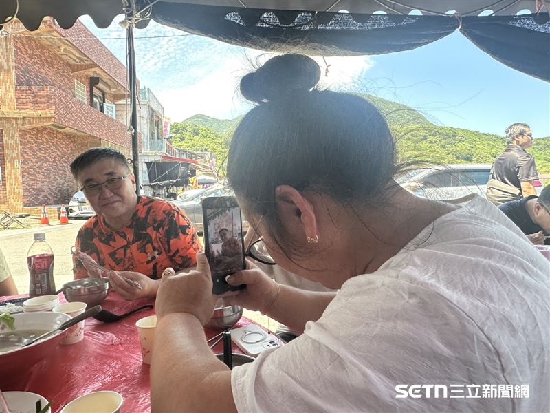 第一次吃海鮮的Tom一家人,媽媽非常認真地幫爸爸拍照留念。(圖/記者張雅筑攝)