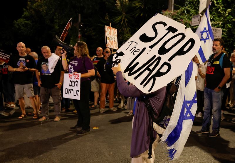 一名示威者在抗議活動中舉著標語，呼籲停止戰爭並釋放人質。（圖／路透社／達志影像）