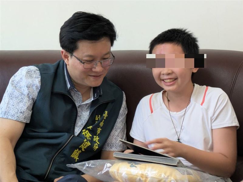 小如（右）開心地拿自己手繪的漫畫跟徐健麟（左）分享。（圖／台南市政府提供）