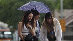 台北強降雨（1）中央氣象署7日下午發布豪雨特報，對流雲系發展旺盛，易有短延時強降雨。圖為台北車站前民眾與親友3人共撐一把傘。中央社記者張皓安攝　114年9月7日