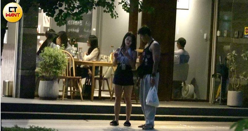 小倆口看著一家餐廳停下腳步，女生拿出手機看似研究餐廳菜單。（圖／CTWANT）
