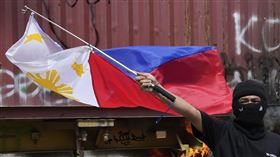 菲律賓21日反貪腐示威爆發警民衝突，抗議民眾火燒卡車來阻擋警方前進，圖中可見示威者揮舞菲律賓國旗。（圖／美聯社／達志影像）