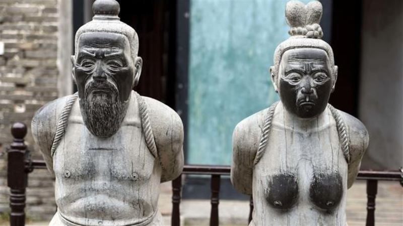 秦檜和他的妻子王氏在岳飛墓前的跪像,女方臉及胸部都被摸黑了,讓秦檜後人向政府抗議。(圖/翻攝自微博)