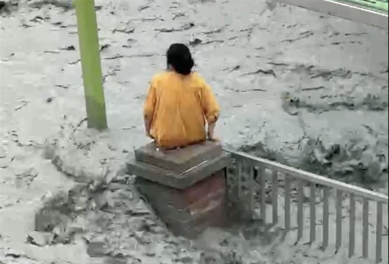 還有民眾不斷縮腳，站在不到一公尺寬的水泥柱上，孤獨待救背影，令人心碎。（圖／翻攝畫面）