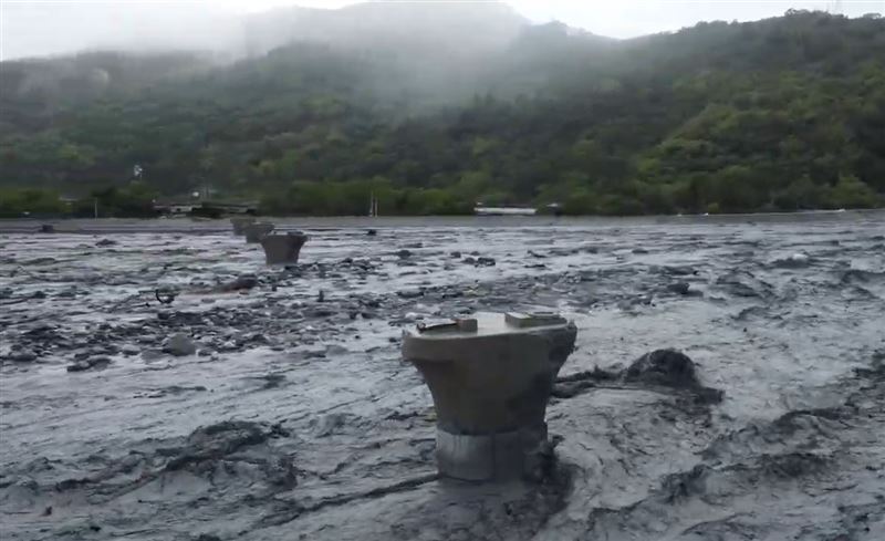 橋體被洪水沖斷好幾截，只剩橋墩留在溪床被黑色洪水不斷拍擊。(圖／翻攝畫面)