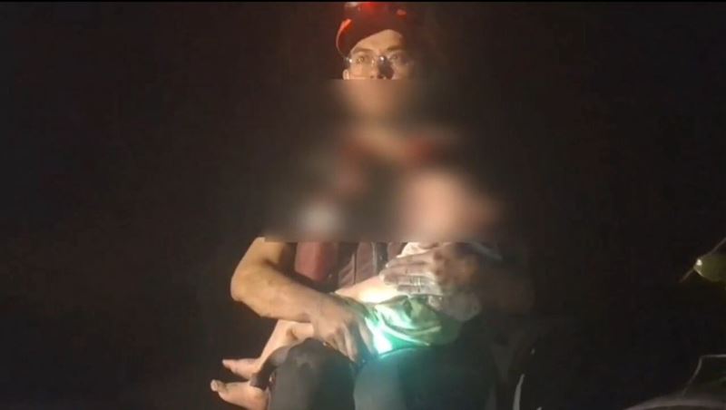 屏東消防局徒步執行光復災區搜救，過程中，搭乘橡皮艇的搜救人員手中緊抱男童並喊話「弟弟不要怕，馬上就帶你出去」。（屏東消防局提供）