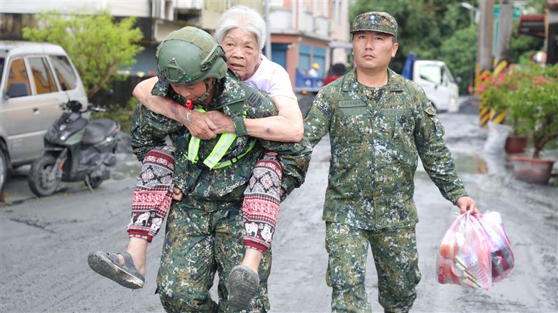 國軍弟兄協助長輩撤離家園。（圖／國防部提供）