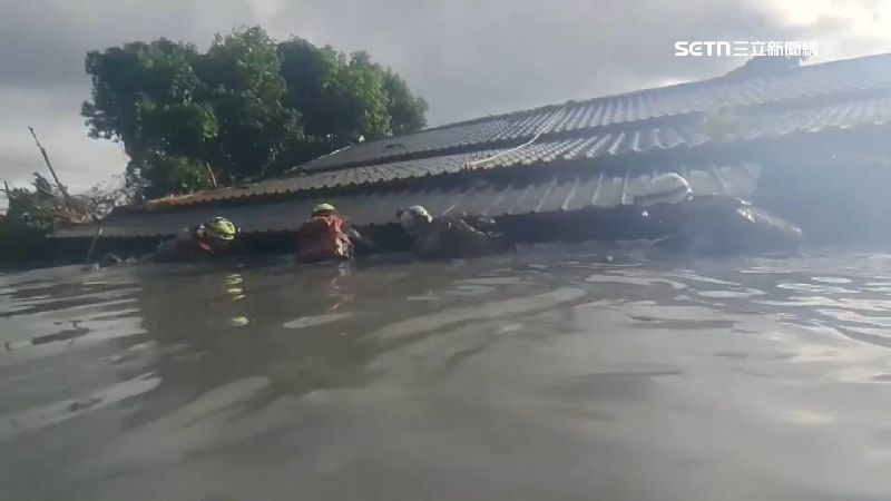 搜救人員泡在混濁泥水裡緩慢移動