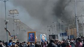 印度拉達克24日爆發暴力衝突，執政黨BJP在當地首府列城的黨部遭縱火，濃煙陣陣。（圖／美聯社／達志影像）