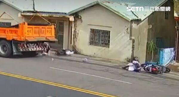 強大衝擊力使兩輛機車翻倒，騎士雙雙受傷倒地，剛好一輛砂石車經過，差點輾過2人。（圖／翻攝畫面）