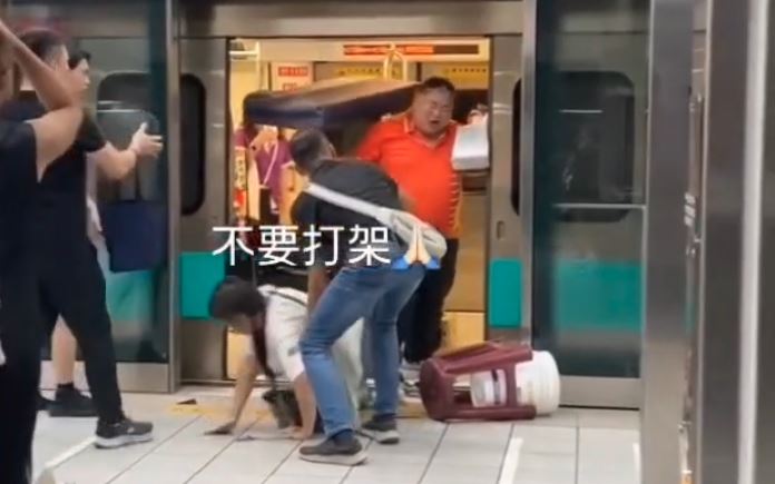 橘衣男好幾拳全往廖男臉上招呼，廖男也不忍了，腳一蹬撲上去，重心不穩反被推出車廂外，重摔橫躺在月台與車廂間空隙。（圖／翻攝自社會事新聞影音畫面）