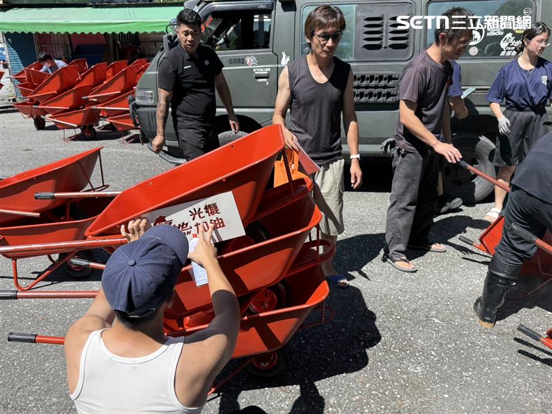 單輪水泥推車在清理泥沙、搬運廢棄家具時特別實用。由於洪水退去後，許多住家及道路堆滿淤泥與雜物，推車成為最迫切需要的工具。(圖/翻攝畫面)