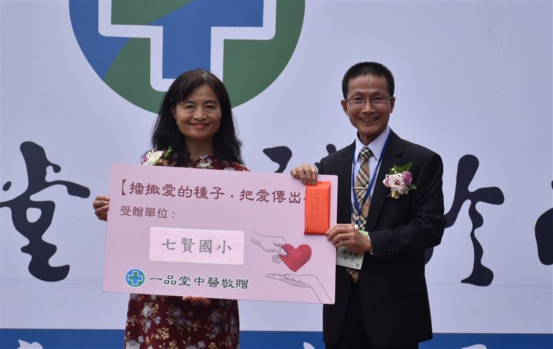 七賢國小校長楊勝任（左）代表接下「一品堂中醫」捐助的善款。（圖／翻攝畫面）