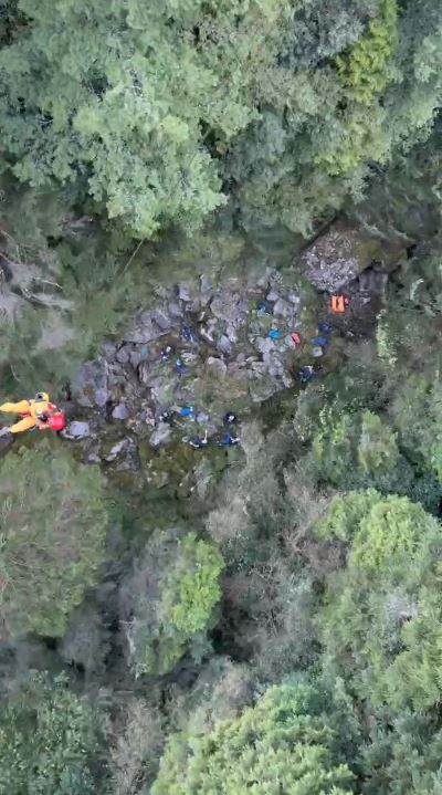 黑鷹直升機以滯空方式，將受傷登山客從溪溝吊掛下山送醫。(圖／空勤第二大隊第三隊提供)