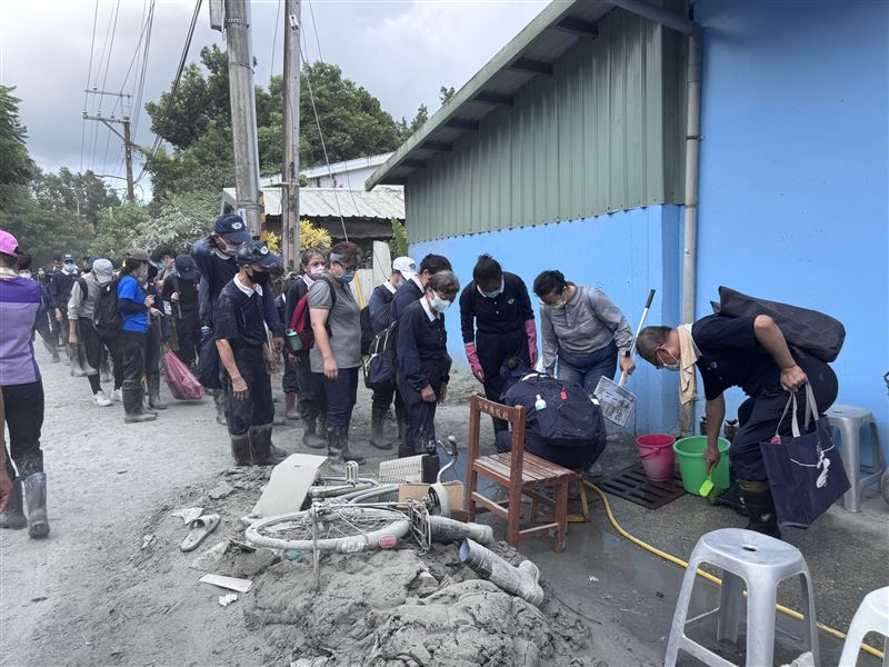 林弘展直擊，清掃志工排隊將沾滿災區污泥的雨鞋清洗乾淨才上車，他說，看到的是「鏟子超人們，最暖心的體貼」。（圖／林弘展提供）