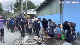 林弘展直擊，清掃志工排隊將沾滿災區污泥的雨鞋清洗乾淨才上車，他說，看到的是「鏟子超人們，最暖心的體貼」。（圖／林弘展提供）
