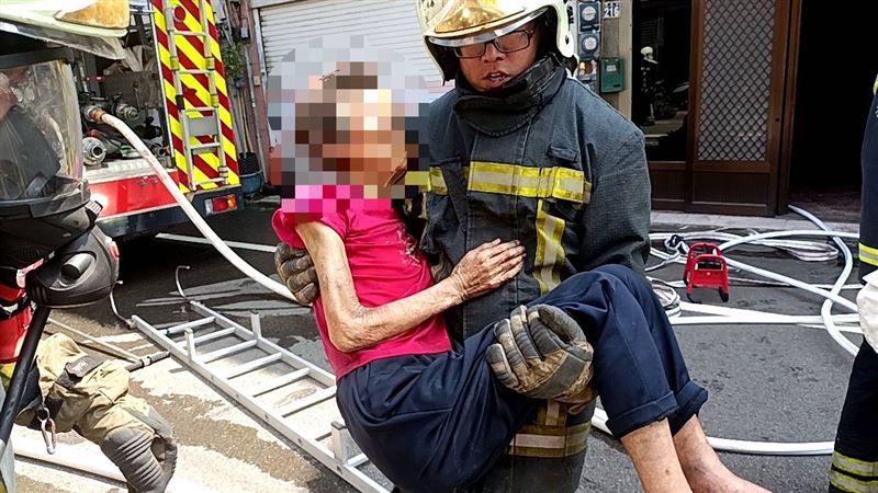 消防員在2樓發現86歲戴姓婦人，以「公主抱」方式將人救出。（圖／翻攝畫面）