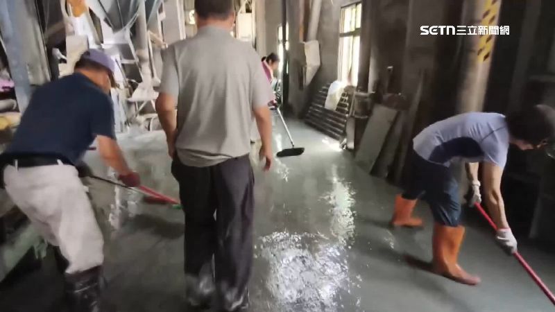 員工忙著把廠裡的淤泥清出