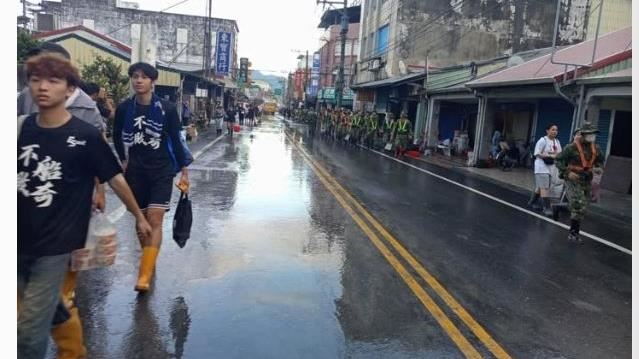 成排國軍持續投入清淤，志工們穿著雨鞋與黑色「不鏟不休」T恤，步伐雖疲憊卻依舊堅定。（圖／Threads little121197）