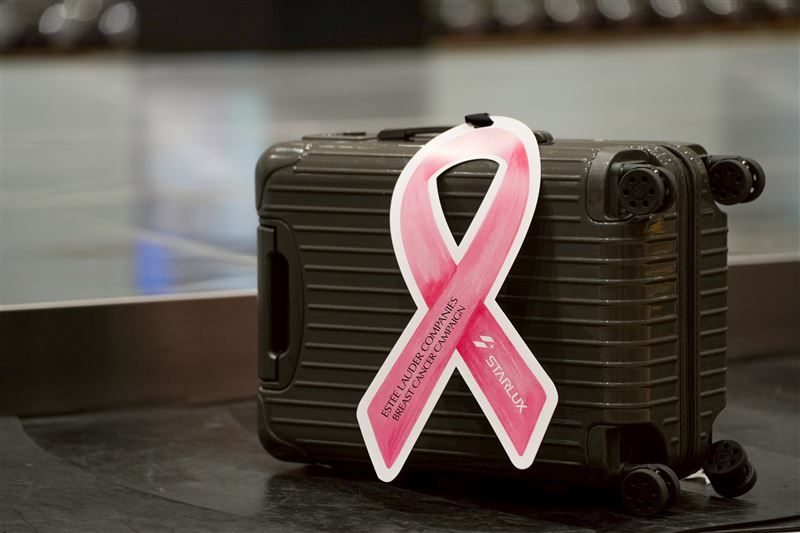 今年星宇航空特別規劃驚喜快閃活動，為抵台旅客的行李繫上巨大粉紅絲帶，並致贈精美禮。（圖／星宇航空提供）