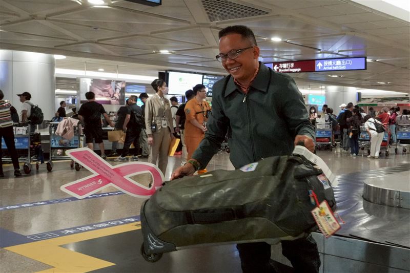 繫上粉紅絲帶的行李箱一一在轉盤現身，現場旅客又驚又喜。（圖／星宇航空提供）