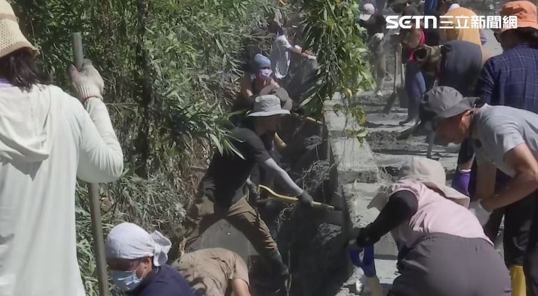 「清溝超人」幫忙清理水溝，一排人在側溝內一鏟一鏟挖淤泥。（圖／翻攝畫面）