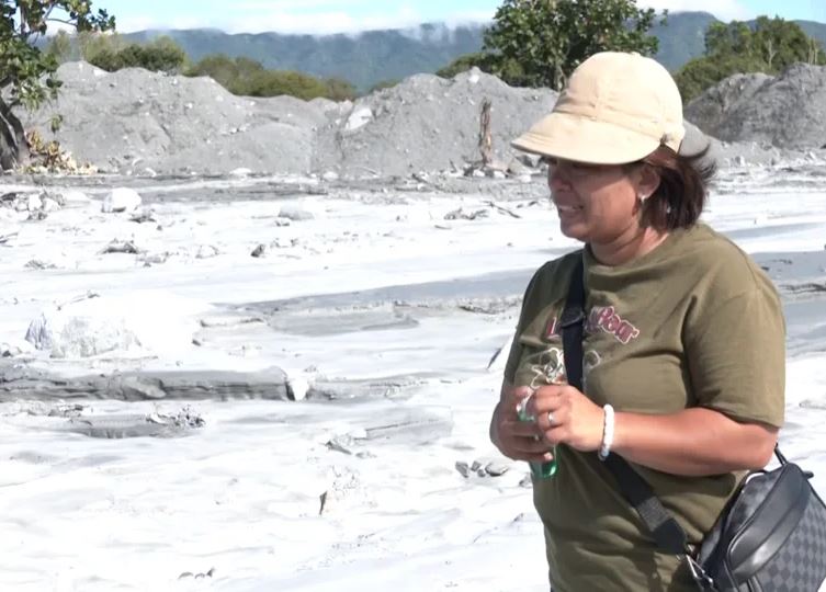 兩老的女兒再度返抵現場尋親，她在淤泥遍布的工寮前噴灑綠油精，希望藉由母親熟悉的氣味引導父母歸來，並當場哽咽失聲。（圖／翻攝畫面）