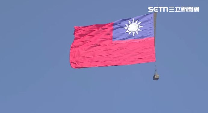 黑鷹直升機護航CH-47SD吊掛巨幅國旗進場。（圖／翻攝畫面）