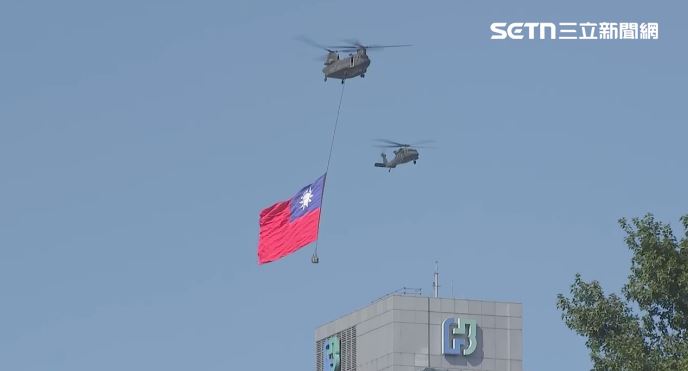 黑鷹直升機護航CH-47SD吊掛巨幅國旗進場。（圖／翻攝畫面）