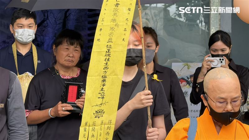 陳嘉齡捧著愛子牌位，走母子倆25年的最後一哩路。（圖／記者簡榮良攝影）