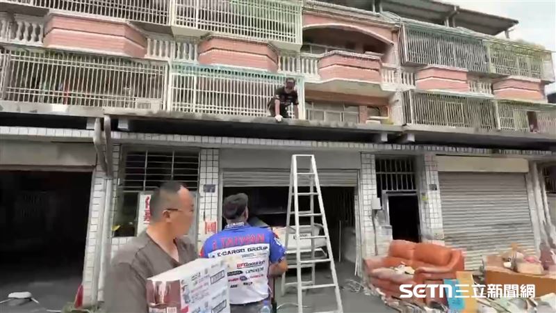 志工們還會自備梯子爬到二樓，將物資遞給受困的居民，若沒有這些志工挨家挨戶的送物資，這些民眾很難被發現他們的困境。（圖／陳和皇授權提供）