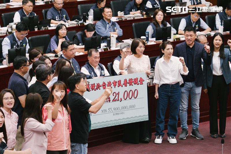民進黨團集體送「普發現金21000元」支票造型紙板給蔣萬安。（圖／記者楊士誼攝影）